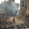 Child on tricycle cycles through destroyed buildings in Gaza