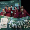 Four team members from Laurel Hill Secondary school stand on a stage with a banner in front of them, after receiving their awards for winning the Concern 2025 Debate final