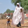 Baria Moumouni carries home packages of fortified flour with her child, distributed by Concern in Tanawara village, Niger. Photo: Concern Worldwide