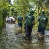 Concern Emergency response team members walk through a submerged road in Noakhali district following the 2024 Bangladesh floods. Photo: Akram Hossain/Concern Worldwide