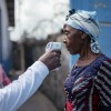A staff member of the CBCA Virunga Hospital checks a visitor's temperature using a contactless infrared thermometer, before allowing her access to the hospital in Goma, DRC