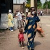 A woman wearing a mask as a preventive measure enters Kyeshero Hospital after passing a checkpoint for hand washing and health screening in Goma