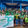 Around 60 people dressed in the green of Concern Worldwide, outside a blue building in Buchanan, LIberia.