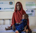 Faizah holding her daughter Malliya in health centre