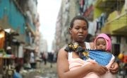 Jacqueline (28) and her daughter Faith (18 months) pictured outside her flat on the street of Pipeline a slum in Nairobi, Kenya. Photo: Jennifer Nolan / Concern Worldwide.
