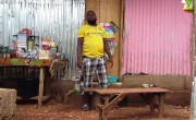 Man stands outside his new home in Kroo Bay.