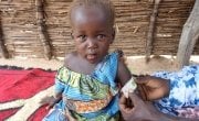 Rafaida, one and a half years old, having her MUAC measurement taken by her mother Khamissa in Doroti, Chad, 2018. Khamissa is a Concern-trained Community Health Volunteer. Photo: Lucy Bloxham / Concern Worldwide.
