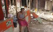 Woman sits on wall surrounded by the ruins of a building destroyed during the earthquake in Haiti
