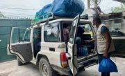 Man takes supplies from the boot of concern jeep vehicle in Haiti
