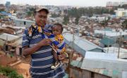Woman holding child against urban slum background