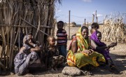 Family sitting on ground outside home