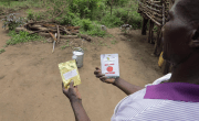 Malawian farmer holding two packets of seeds