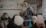 A woman stands up and addresses a support session in Ukraine