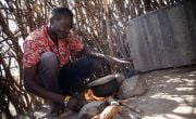 Kenyan pastoralist Ereng Kaleng Kalimapuse boils pot over fire 