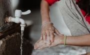 Woman washes her hands with tap in Iraq IDP site