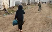 Children walk and cycle through Iraq IDP site