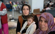 Irmine holds infant daughter on her lap in exhibition centre in Turkiye