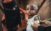 Community health worker assessing infant in Yemen 