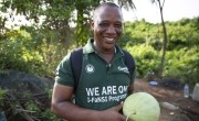 Mohamed Barnes, Concern Field Assistant on IFaNSI programme, holds a watermelon on a farm near Buchanan (Photo: Kieran McConville/Concern Worldwide)