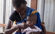 Nyapuoka Kai feeds her baby a packet of RUTF at an outpatient nutrition center in South Sudan. (Photo: Jon Hozier-Bryne)