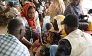 Concern Health and Nutrition Officer, Yamen Nassir, with Zarina* and baby Yaqub* at Ardamata Health Centre in West Darfur, Sudan. Yaqub* is severely acutely malnourished and has additional health complications. Photo: Kieran McConville/Concern Worldwide