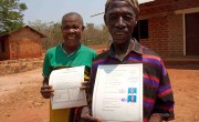 Village Chairperson, Paulo Christopher presenting Mustafa Kibibi Balizila and Mwajuma Ramadhani Kachira with their joint Land certificate in Kigoma Region, Tanzania. Photo: Jennifer O'Gorman/Concern Worldwide