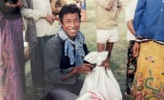 A returnee to Cambodia receives a kit with blankets, a mosquito net, and kitchen supplies, 1991. Photo: Concern Worldwide