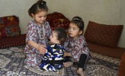 Hafez* at home with two of his sisters. Photo: Nava Jamshidi/Concern Worldwide