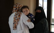 Hasan* (with mother Malalai* in the background) is seen by a midwife at a Concern-supported Family Health House. Photo: Nava Jamshidi/Concern Worldwide