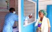 Divine Okize, whose son is ill, undergoes a temperature check at a Health Centre in Goma.