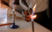 A students uses a bunsen burner for an experiment