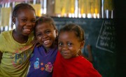 Students Pleasant, Handful and Pennita in their classroom