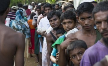 Rohingya men from Myanmar queue at a distribution site at Hakim Para in Cox's Bazar, Bangladesdh. Photo: Kieran McConville / Concern Worldwide.