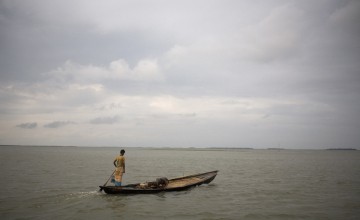 A lone boatman travels accross the Haor flood plains of North East Bangladesh.