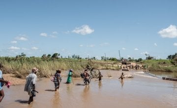 People wade across a river in flood near Nhamatanda, Mozambique. Cyclone Idai has disrupted infrastructure across the country, impacting livelihoods and hampering aid efforts. Photo: Tommy Trenchard / Concern Worldwide.