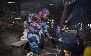 A woman sits with her child in her temporary accommodation.