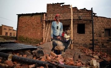 Violette Bukeyeneza outside her dilapidated house with her goat. Photo: Darren Vaughan/Concern.