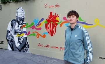 Artist Emmalene Blake standing in front of the mural she painted for International Day of Peace. Photo: Concern worldwide.