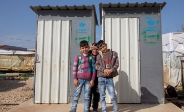 Children from an ITS camp in Northern Lebanon pose beside latrines Concern built. 