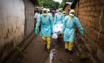 A burial team collects a corpse from inside a house in the east of Freetown, Sierra Leone.