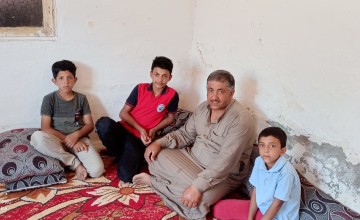 Samar sitting with his brothers and father. Photo: Concern Worldwide. 