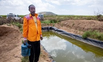 A lead farmer stands by his water catchment system in North Somaliland. As part of the climate change adaptation work, Concern provided him with a tarpaulin to which he has sank into a hole to store as much water as he can for his crops during the dry season. 