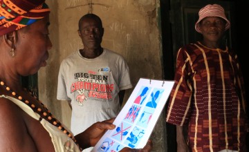 A resident of Bassaia Village looks at a COVID-19 poster. 