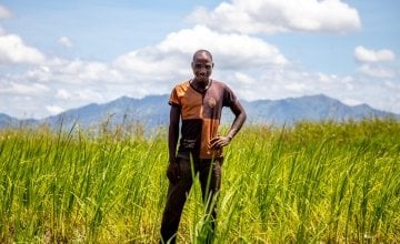 Patrick Ghembo stands in front of the crops which Concern helped him to grow after Cyclone Idai destroyed his harvest in 2019.