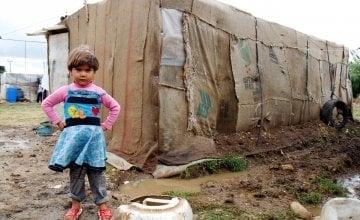A refugee child stands in front of her home in an informal tented settlement in Akkar district.