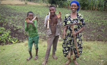 Female Ethiopian farmer with her sons in her field