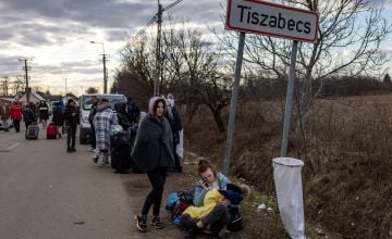  People wait with their belongings at the Tiszabecs-Tiszaujlak border crossing as they flee Ukraine on February 27, 2022 in Tiszabecs, Hungary. Photo by Janos Kummer/Getty Images