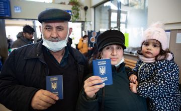 Family holding up Ukrainian passports