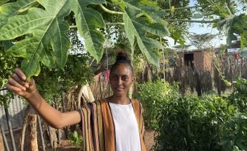 Young woman standing in a kitchen garden in Kenya