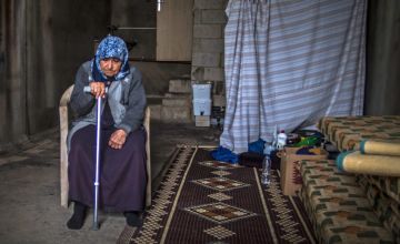 A Syrian refugee woman sits in her informal home in Lebanon